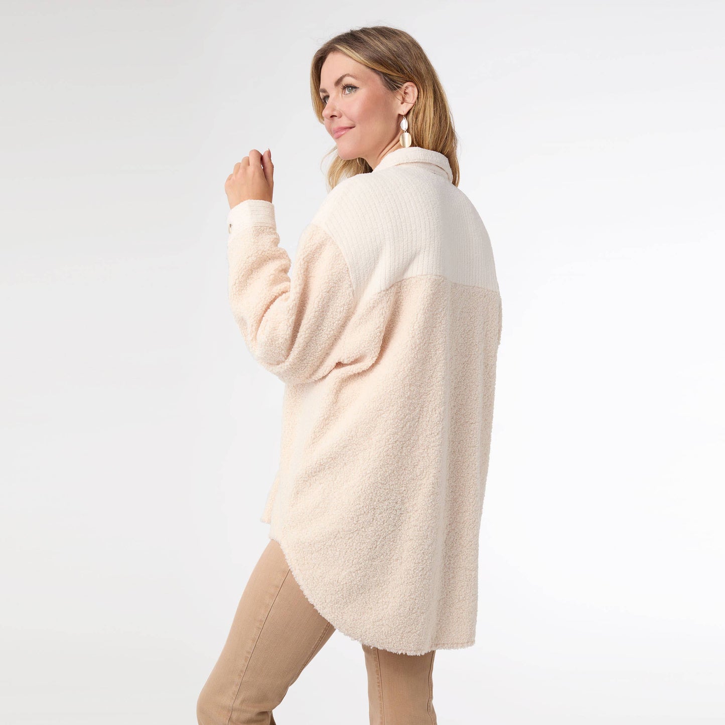 Woman wearing a cream-colored oversized sweater on a white background