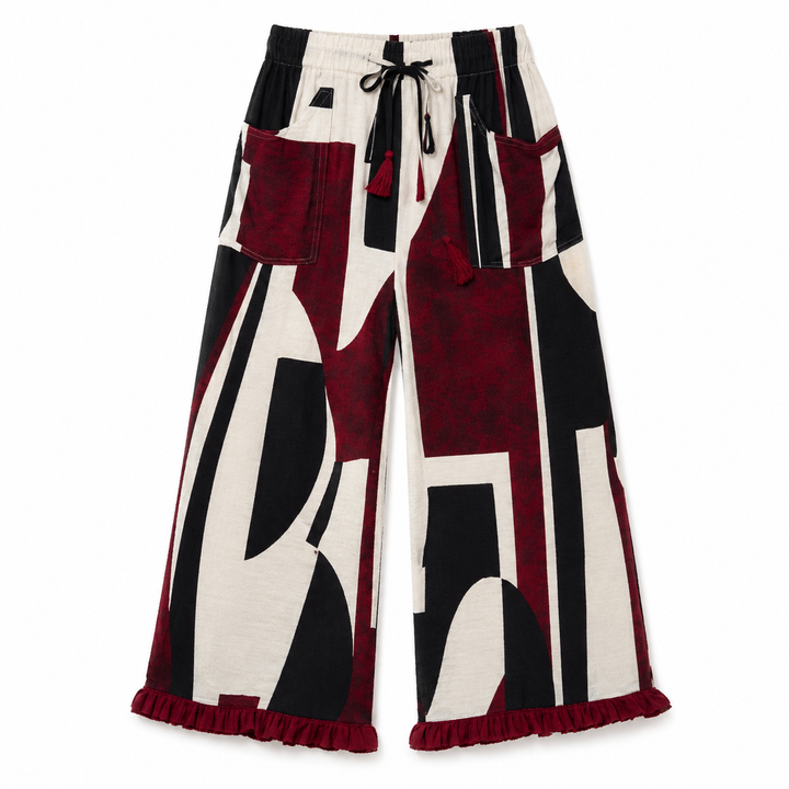 Wide-leg cropped pants featuring an abstract geometric pattern in black, off-white, and deep burgundy, with a drawstring waist, front patch pockets, and a ruffled hem.