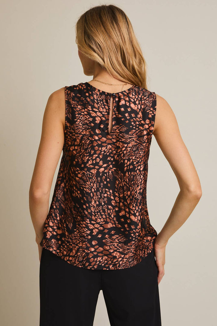 Woman wearing a sleeveless top with a pattern on a plain background