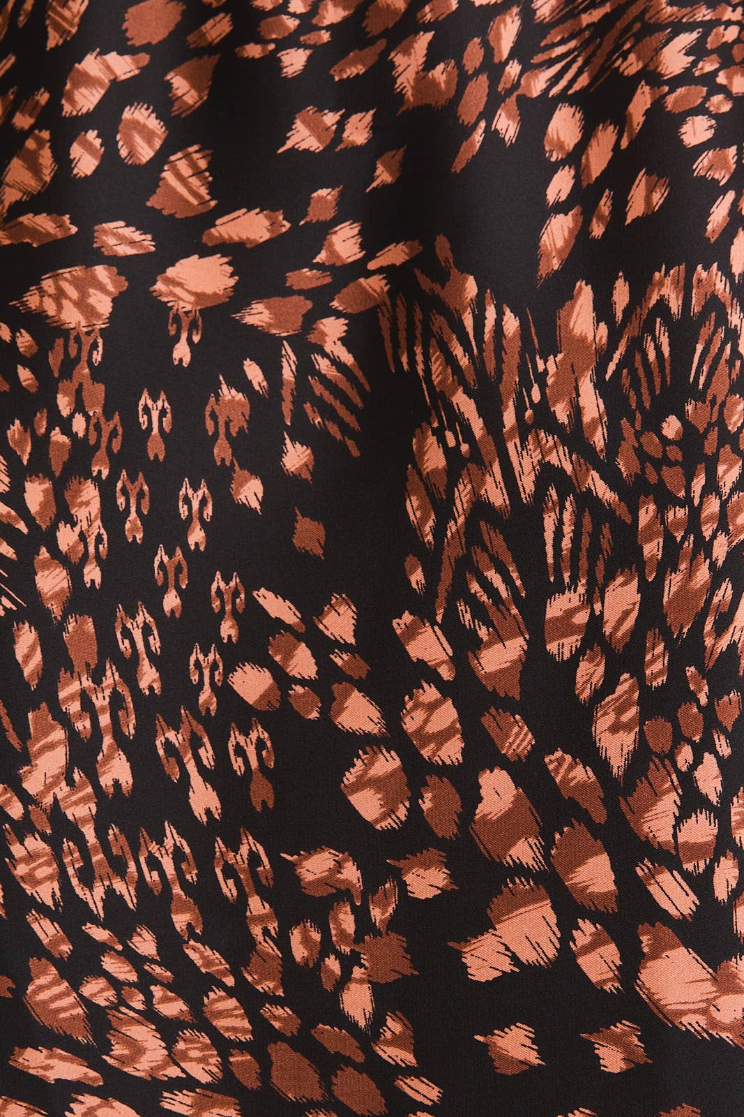 Close-up of fabric with brown abstract pattern on black background