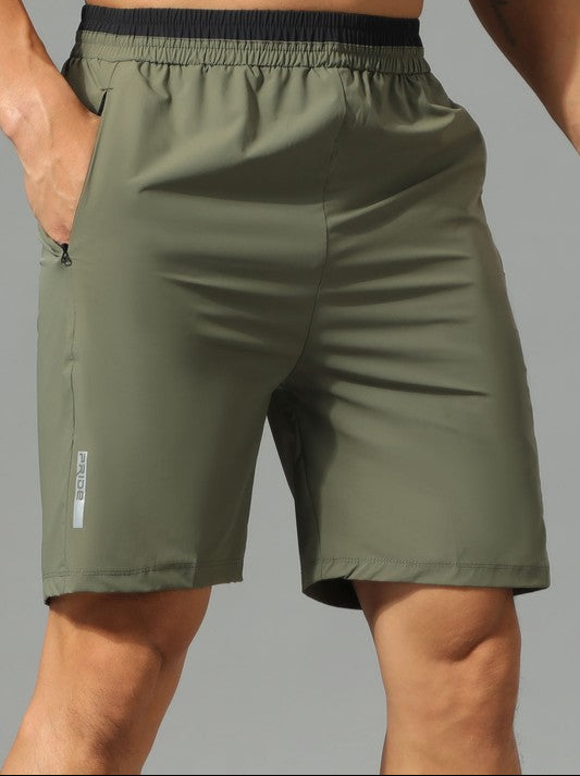 Green athletic shorts worn by a person on a gray background