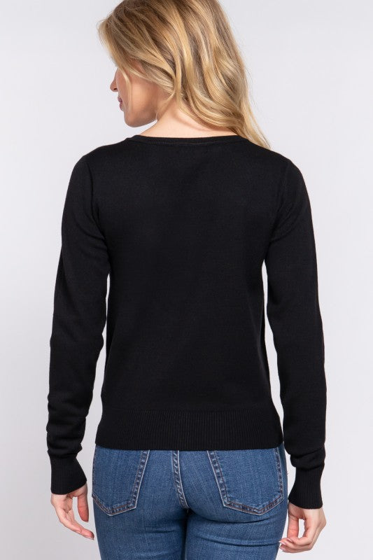 Person wearing a black sweater and blue jeans on a white background
