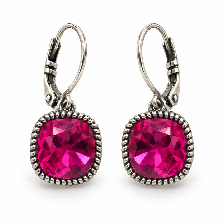A pair of silver leverback drop earrings featuring large, round, faceted hot pink gemstones in a textured silver bezel setting, shown on a plain white background.