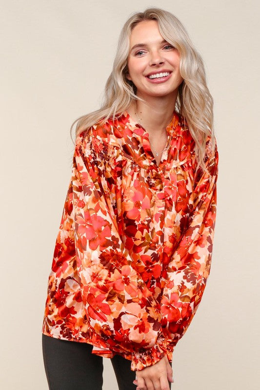 Woman wearing a red floral blouse against a beige background