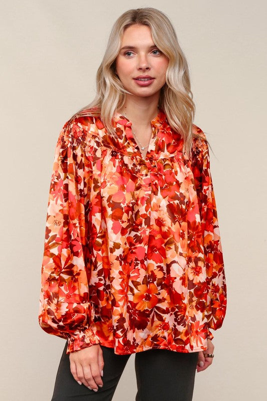 Woman wearing a red floral blouse against a beige background