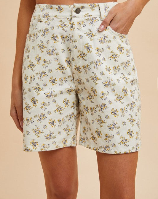 Floral shorts worn by a person on a beige background
