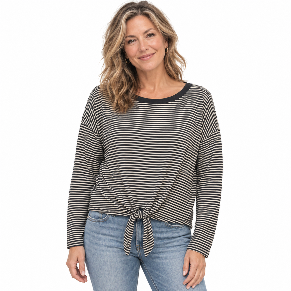 A woman modeling a black and white horizontally striped long-sleeve top with a crew neck and front knot detail, paired with blue jeans, against a plain white background.