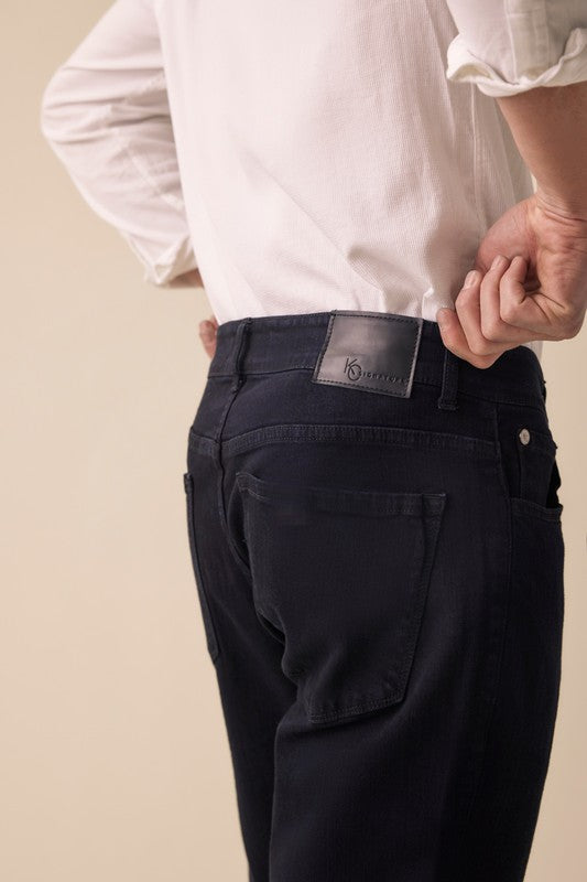 Person wearing black pants with a visible brand label on a beige background