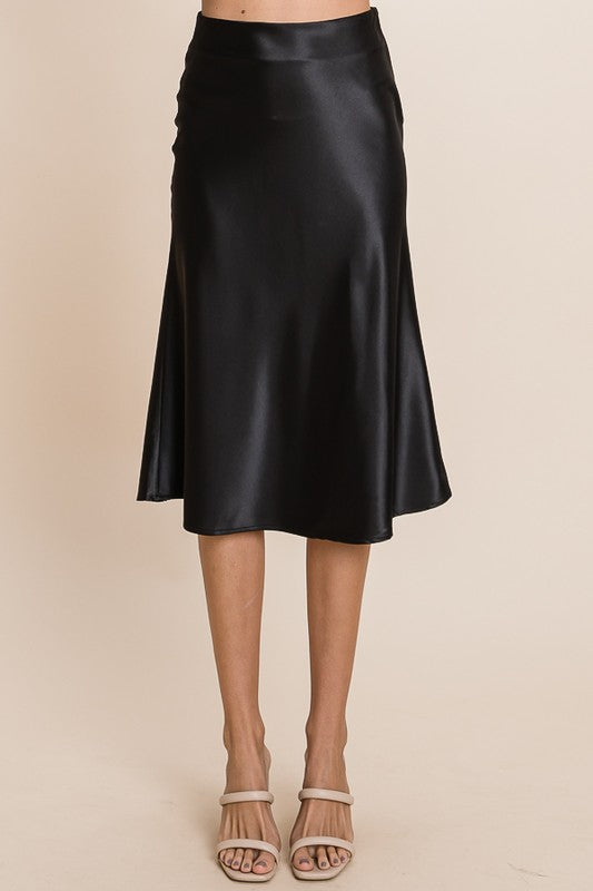 Black satin skirt worn by a person on a beige background