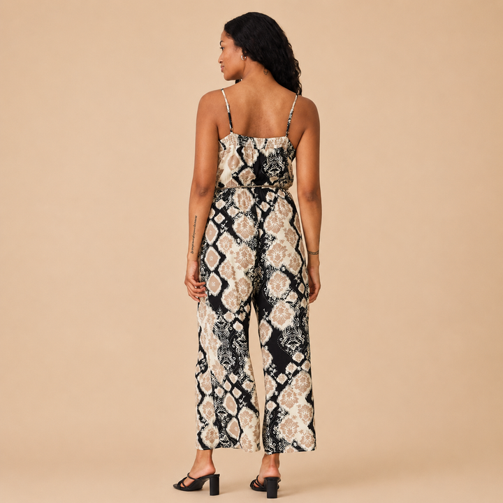 Woman wearing a floral jumpsuit on a beige background