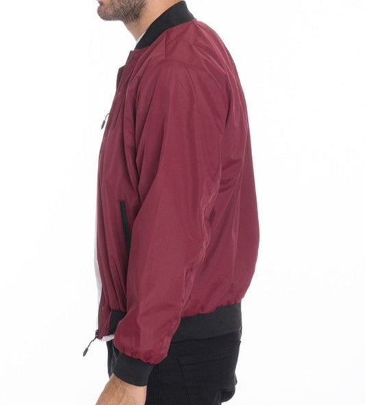 Maroon bomber jacket worn by a person on a white background