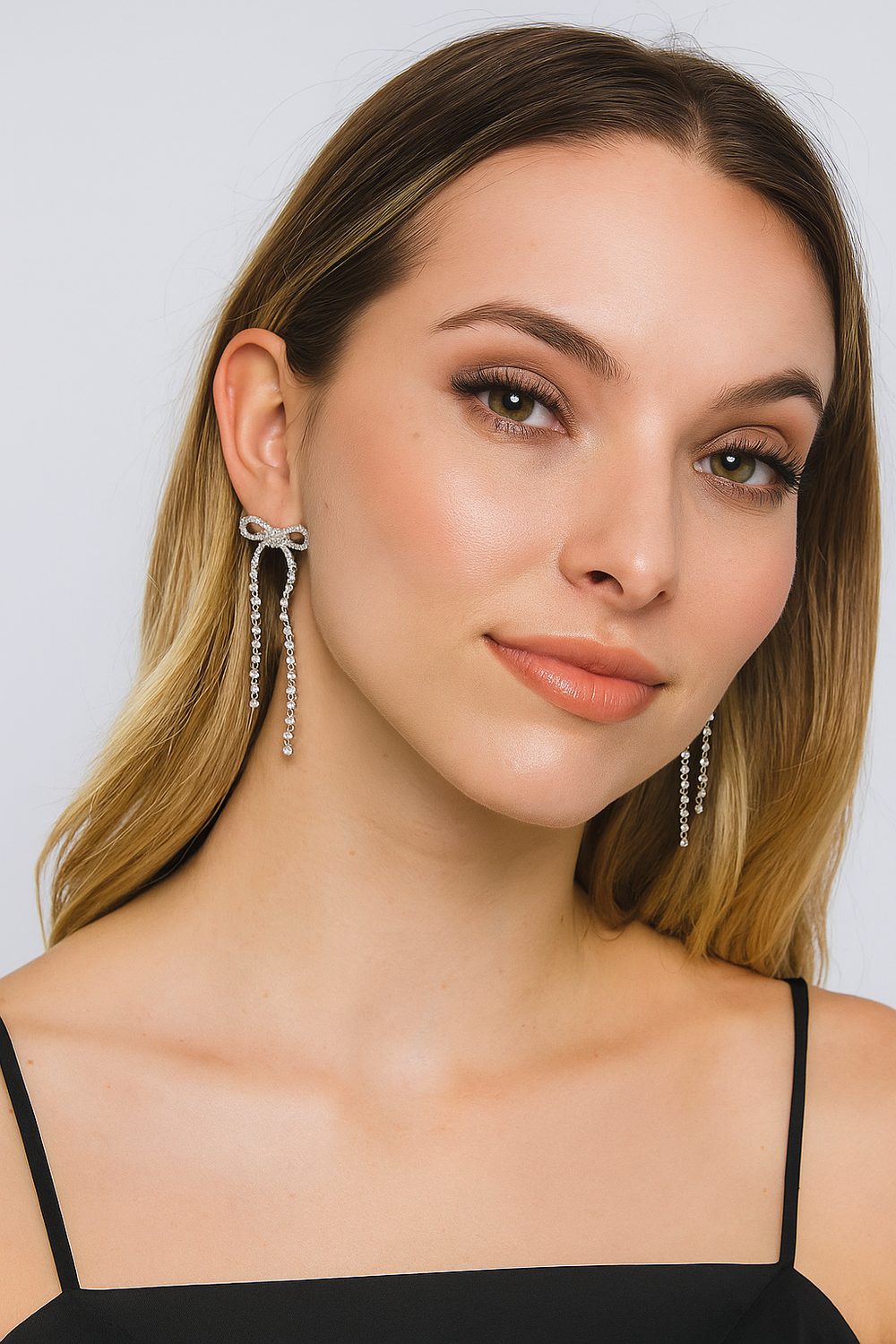 Woman wearing elegant earrings against a neutral background