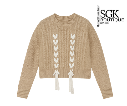 Beige sweater with lace-up design on a white background, featuring SGK Boutique logo.
