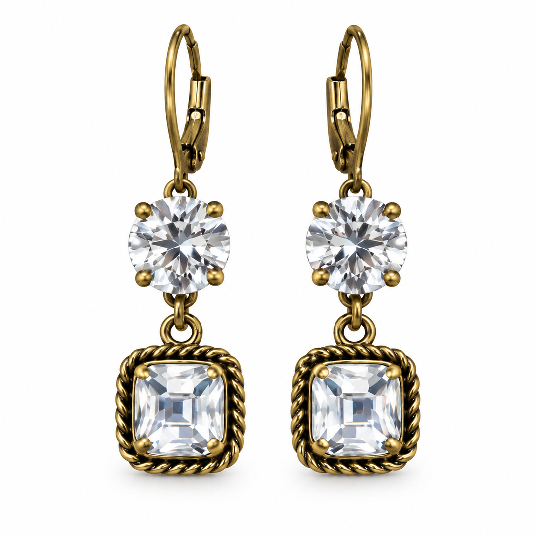 A pair of gold leverback drop earrings featuring a round clear crystal and a square bezel-set clear crystal with a twisted rope border, shown on a plain white background.