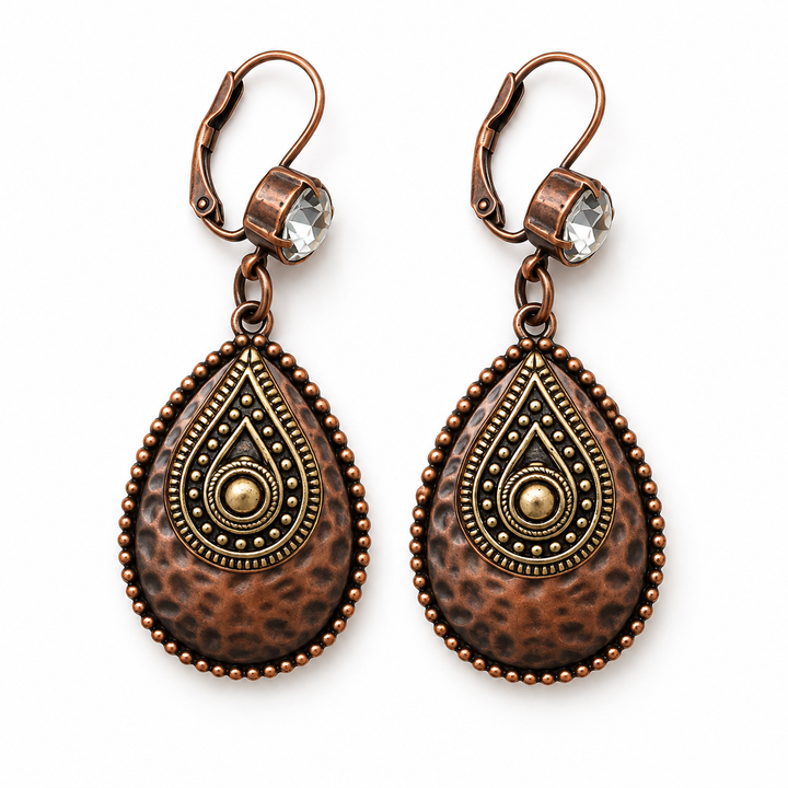 A pair of antique copper drop earrings with teardrop-shaped charms featuring a textured copper and gold-tone paisley pattern, accented with clear rhinestones in the ear wires, shown on a plain white background.