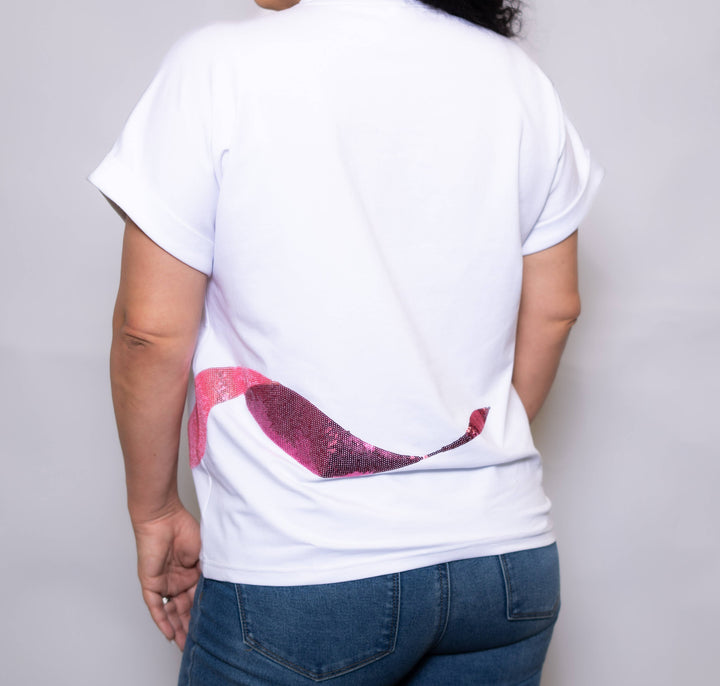 Person wearing a white t-shirt with a red and black design on the back, standing against a plain background.