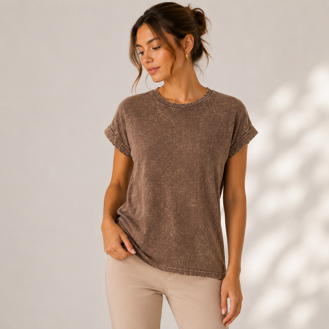 Woman wearing a brown t-shirt and beige pants against a neutral background