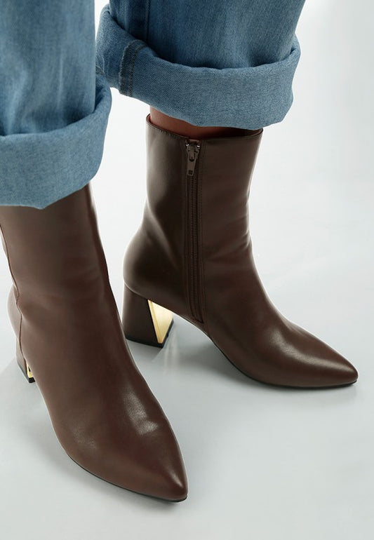 Brown leather boots with a gold zipper on a light gray background