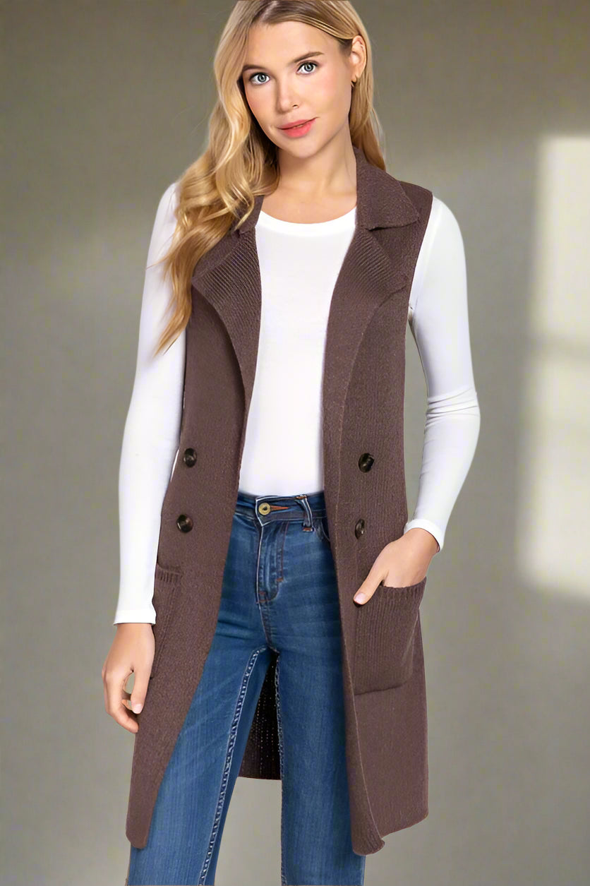 Woman wearing a brown coat, white shirt, and blue jeans on a light gray background