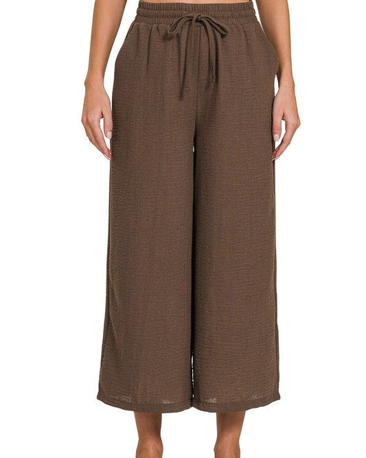 Brown wide-leg pants with a drawstring waist on a white background