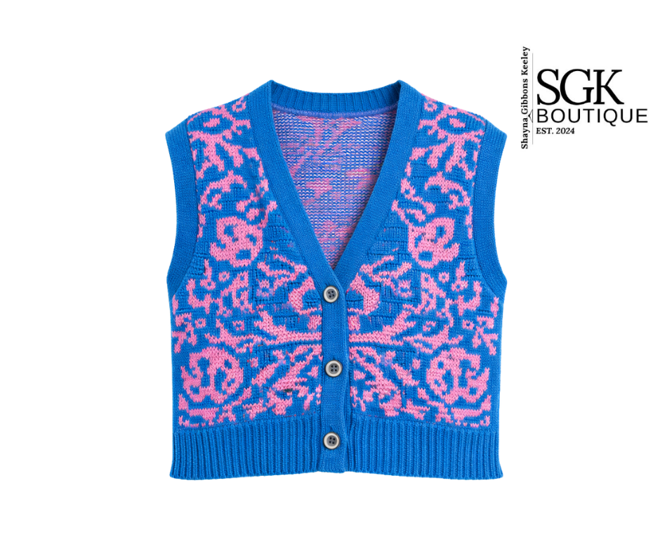 Blue knitted vest with pink pattern on a white background, featuring the SGK Boutique logo.