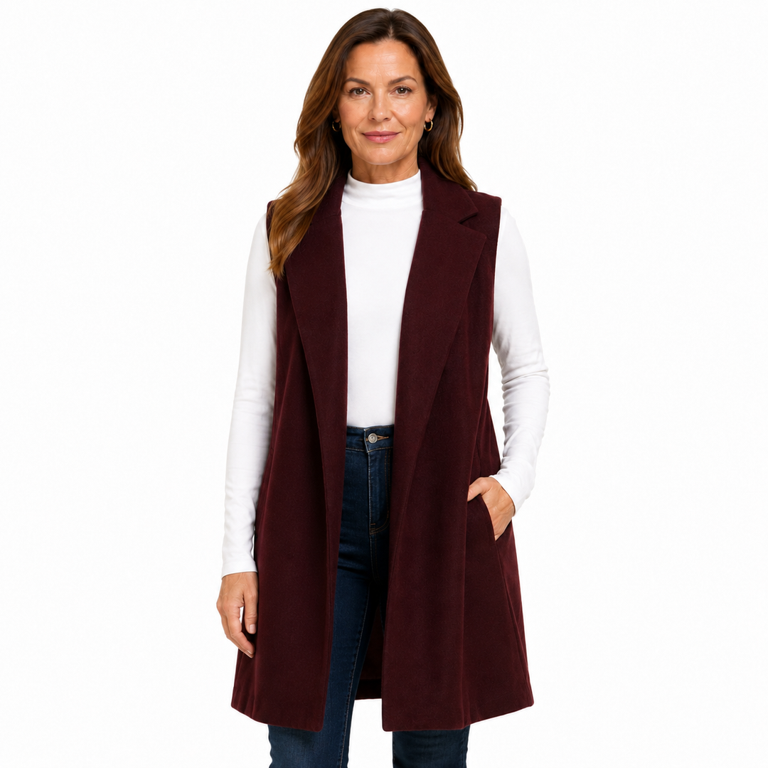 A woman modeling a long, sleeveless, open-front vest in deep burgundy over a white mock-neck top and dark blue jeans, shot against a solid white background.