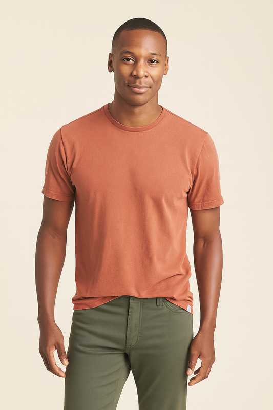 Man wearing a brown t-shirt and green pants against a beige background