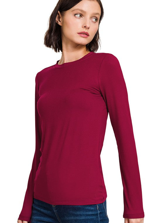 Woman wearing a burgundy long-sleeve top on a white background