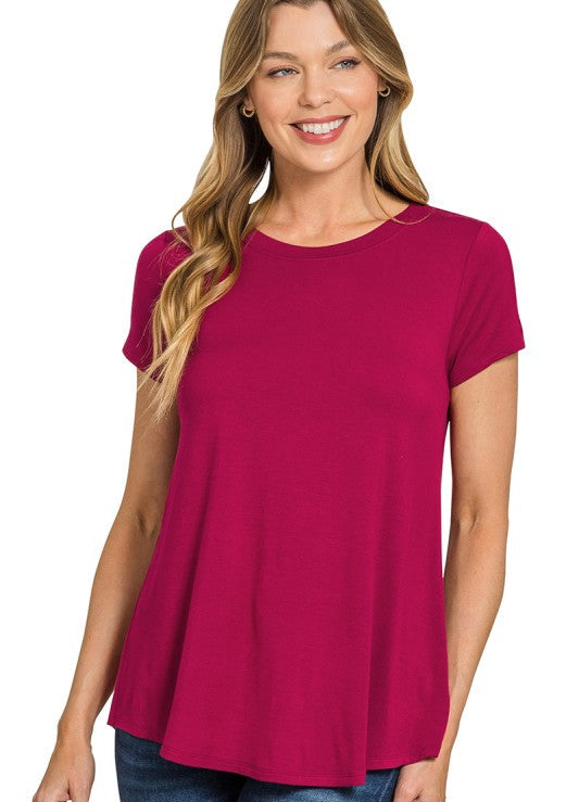 Woman wearing a cabernet-colored t-shirt on a white background
