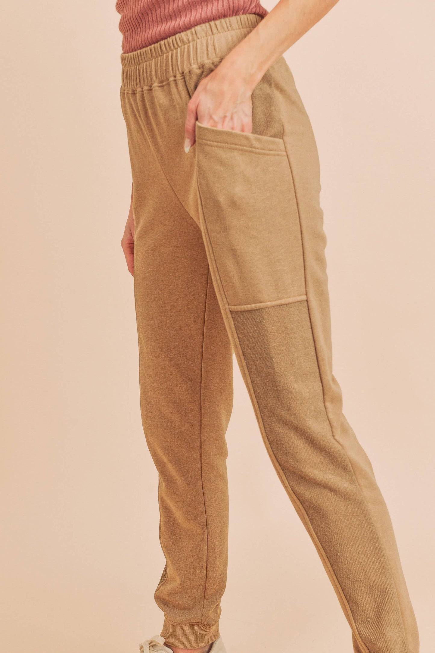 Tan jogger pants worn by a person on a beige background