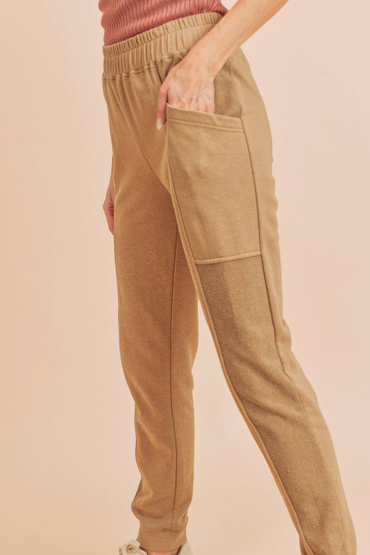 Tan jogger pants worn by a person on a beige background