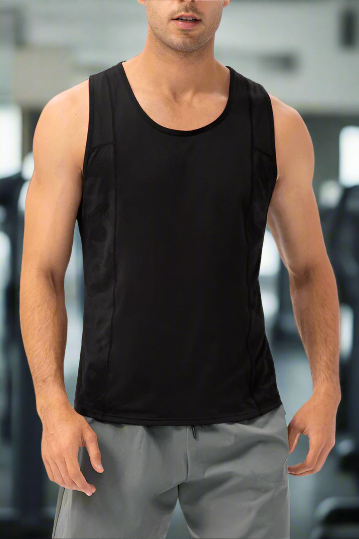 Man wearing a black sleeveless shirt and gray pants on a white background