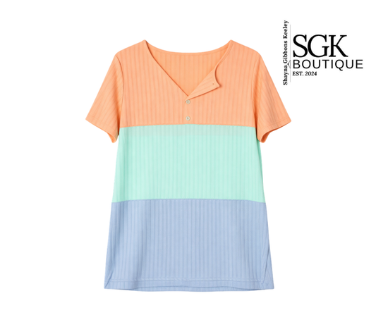Color-blocked dress with orange, green, and blue sections on a white background, featuring SGK Boutique branding.