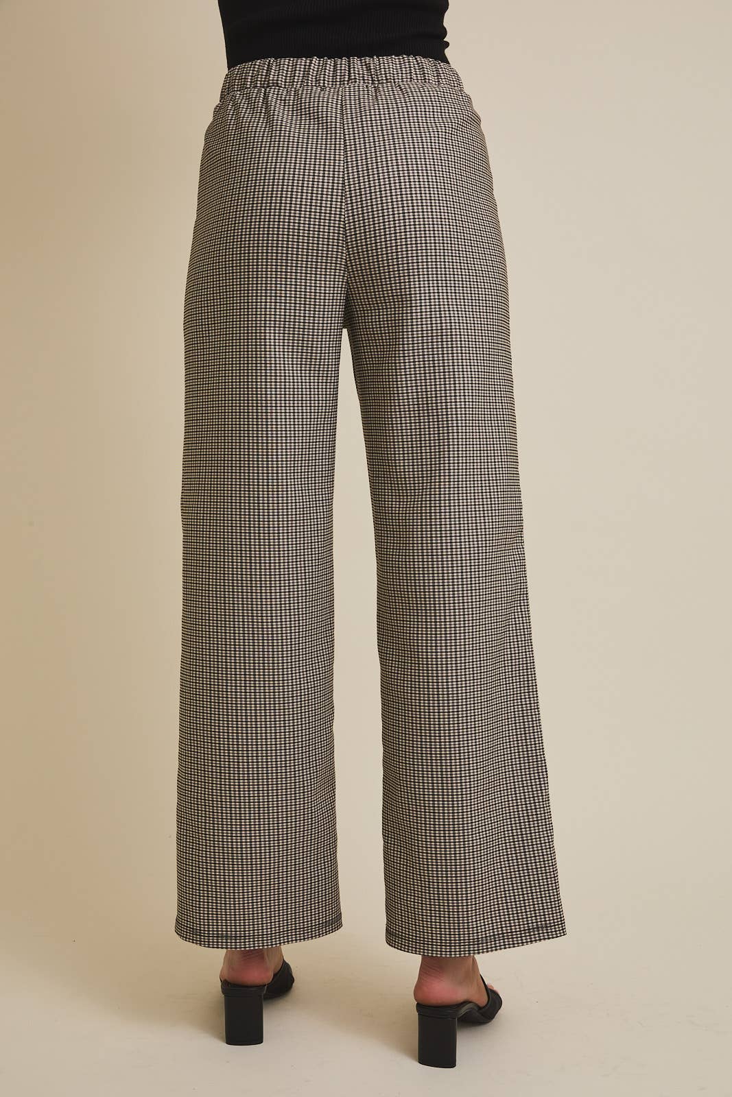 Checkered pants worn by a person on a beige background