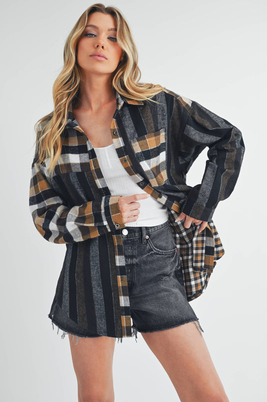 Woman wearing a plaid shirt over a white top and denim shorts on a white background