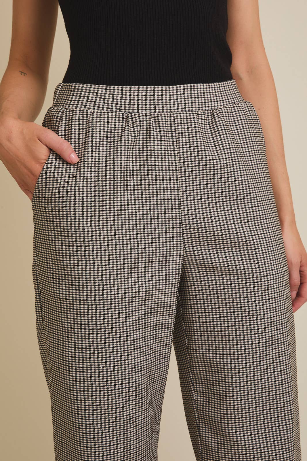 Person wearing plaid pants with a plain background