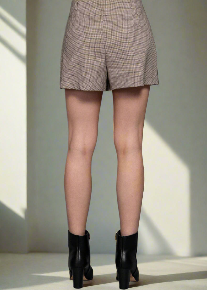 Person wearing beige checkered shorts on a gray background