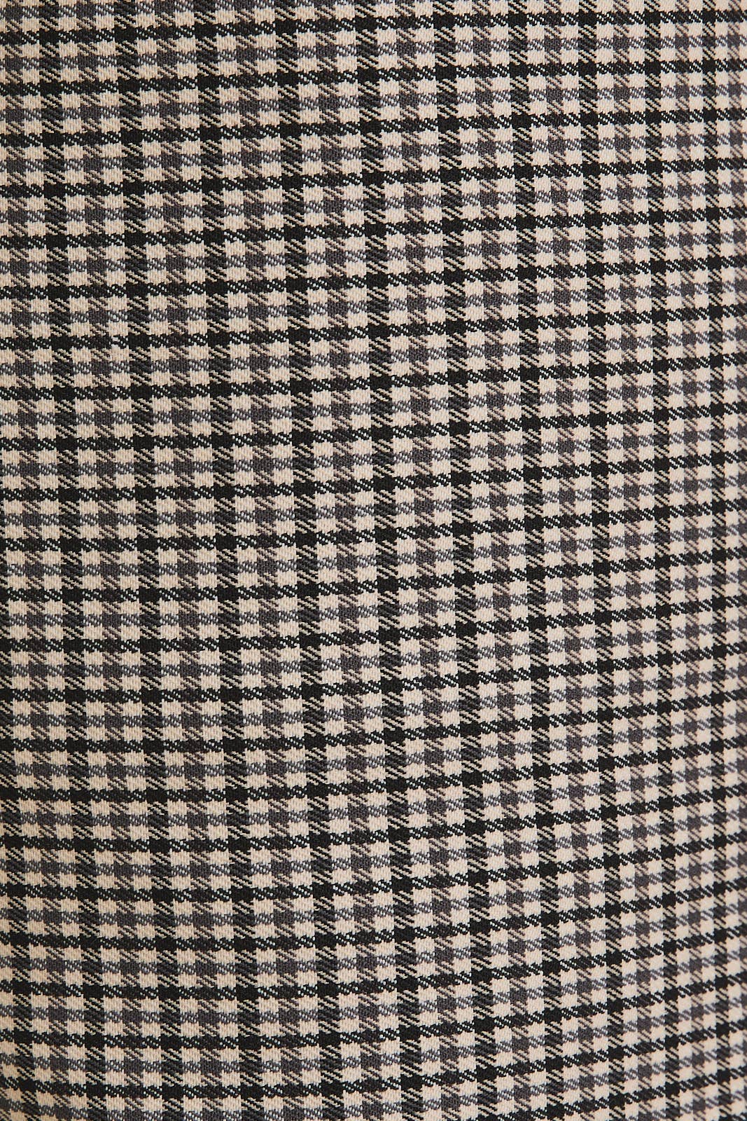 Close-up of a houndstooth pattern fabric with black and beige colors.