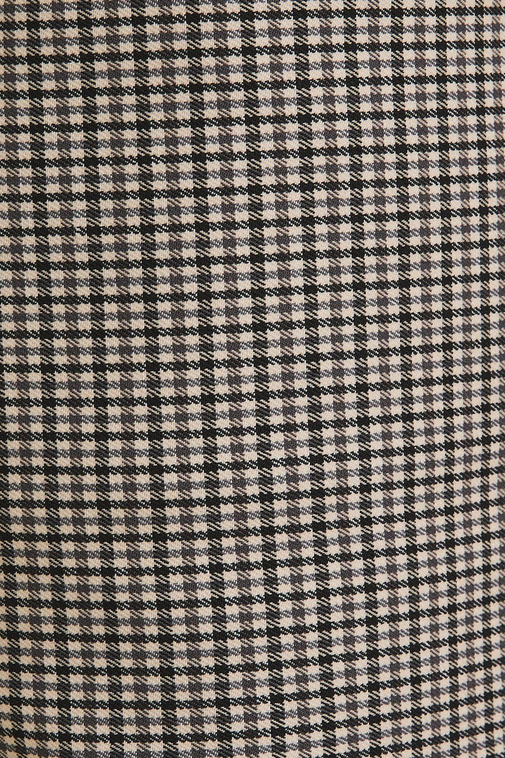 Close-up of a houndstooth pattern fabric with black and beige colors.