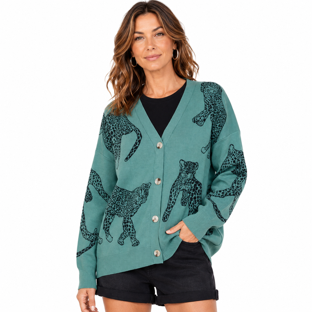 A woman modeling a teal cardigan with a black leopard print pattern, worn over a black top and black shorts against a plain white background.