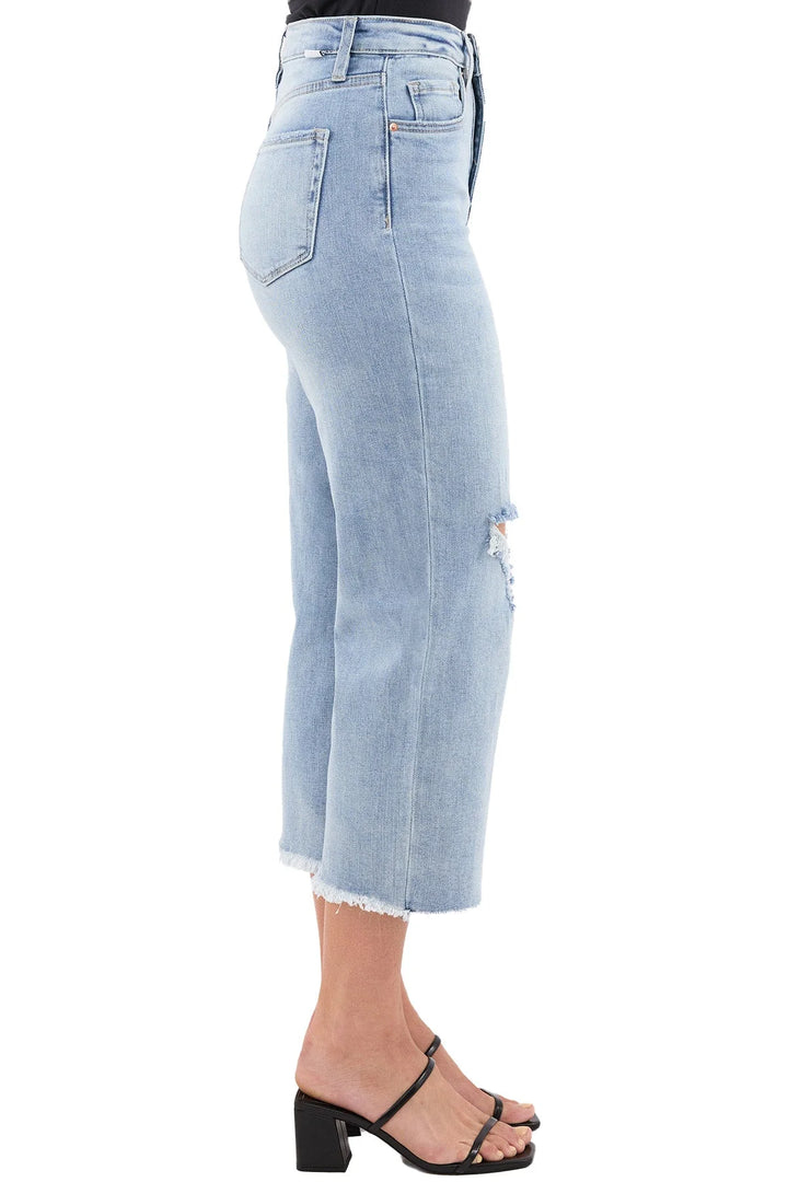 Light blue jeans being worn on a plain background
