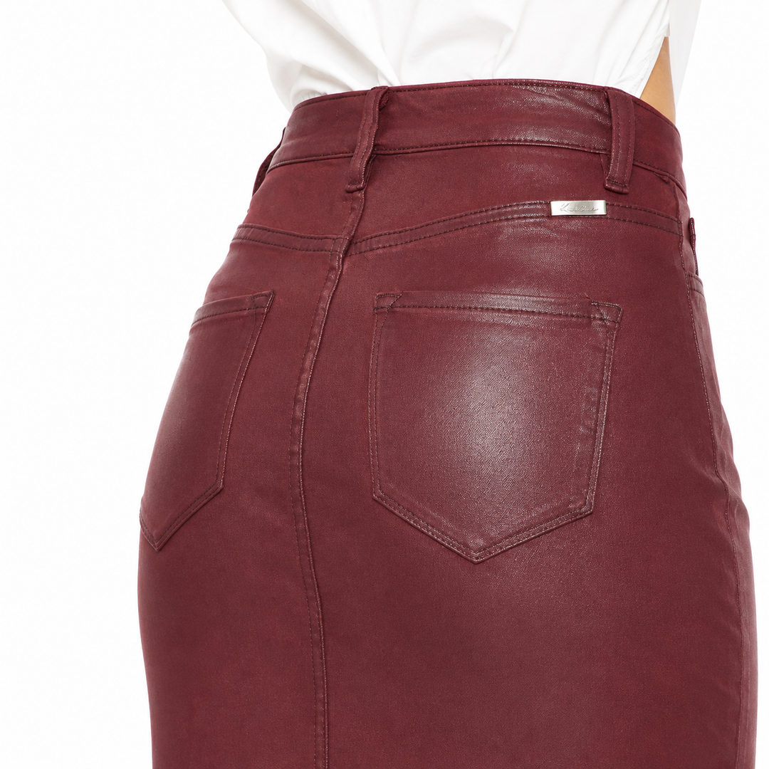 Close-up of the back waistband and pockets of a burgundy faux-leather pencil skirt, worn with a white top against a white background.