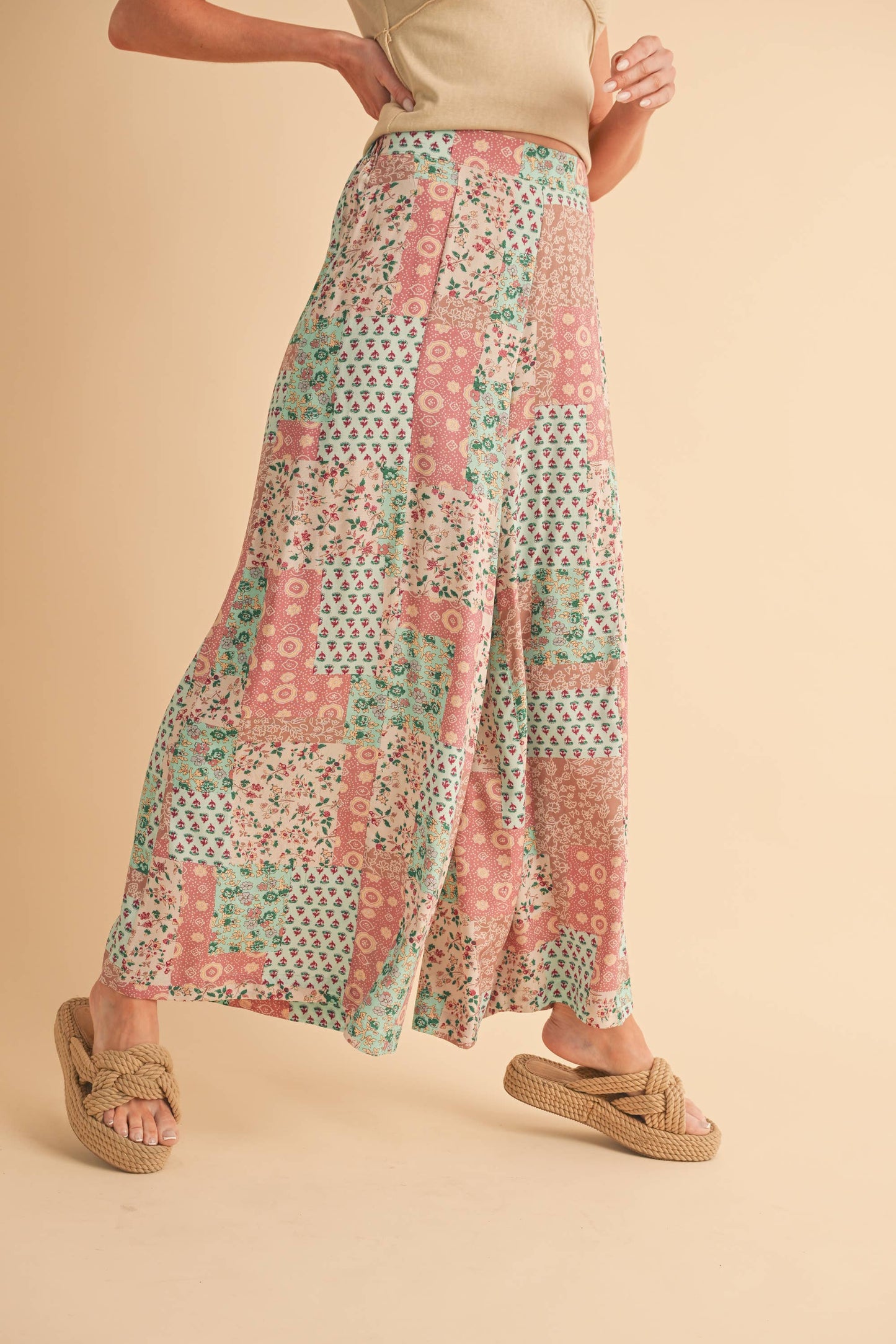 Person wearing a patterned pant on a beige background