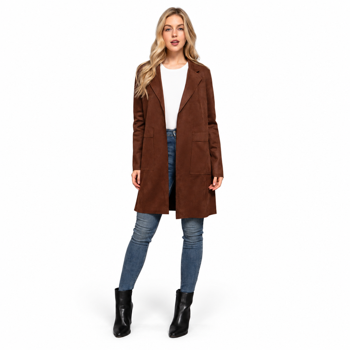 A woman modeling a brown mid-length suede-like coat over a white top, blue jeans, and black ankle boots, photographed against a plain white studio background.