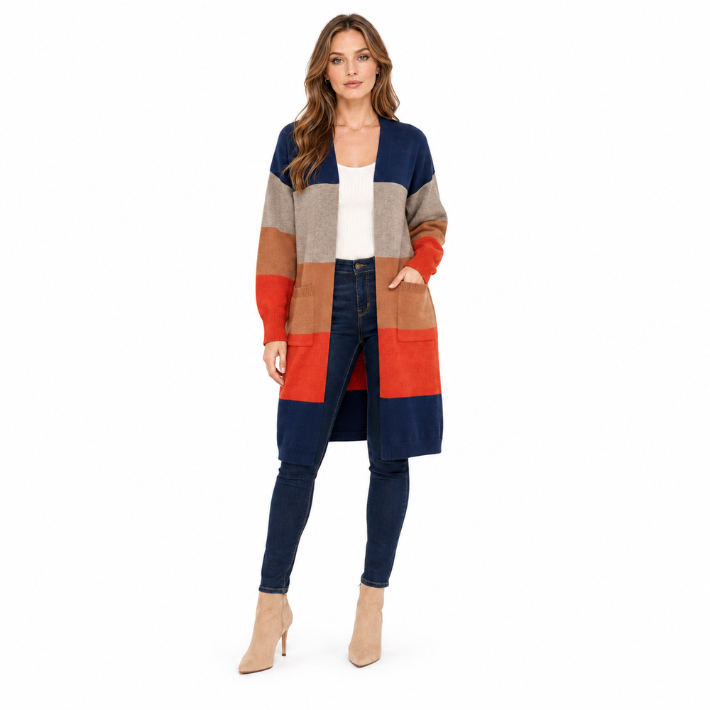 A woman modeling a long color-block knit cardigan with navy, beige, tan, and rust-orange panels, worn over a white top and dark blue skinny jeans against a plain white background.