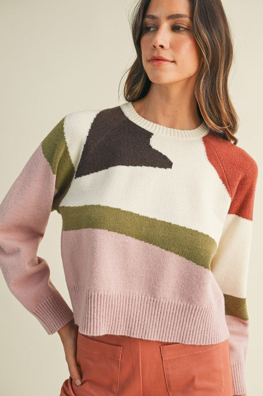 Woman wearing a colorful sweater with a neutral background