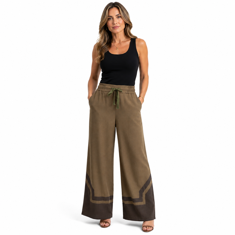 A woman modeling wide-leg pants in a brownish-olive khaki color with a dark brown geometric stripe detail near the hems, paired with a black tank top, on a solid white background.