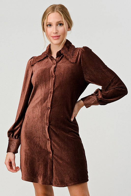Woman wearing a brown corduroy dress against a plain background