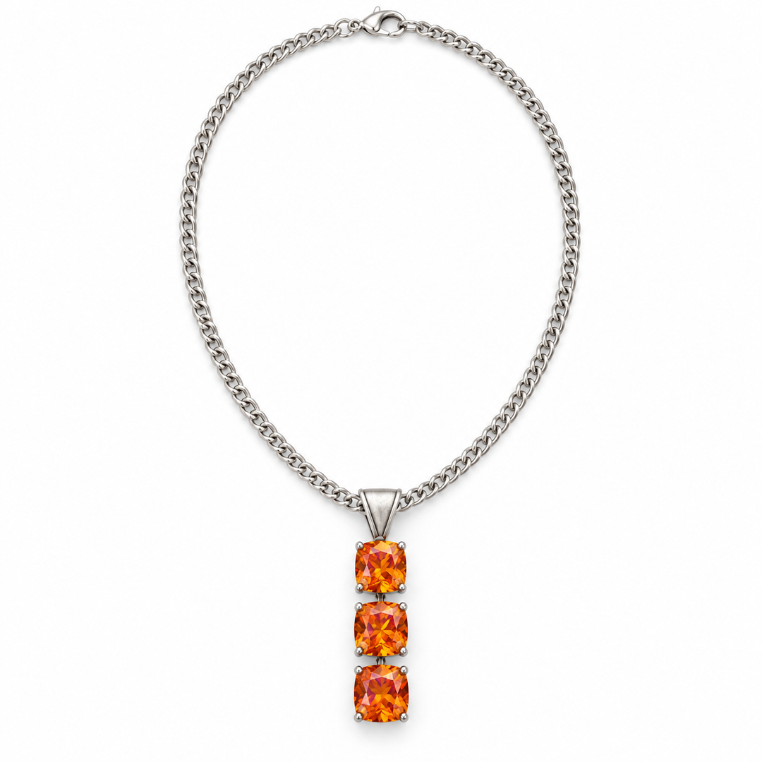 A silver-toned curb chain necklace featuring a vertical pendant with three stacked square-cut orange gemstones, shown on a plain white background.