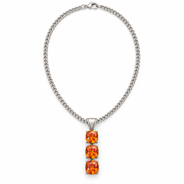 A silver-toned curb chain necklace featuring a vertical pendant with three stacked square-cut orange gemstones, shown on a plain white background.